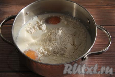 Влить в кастрюлю молоко, добавить яйца, затем всыпать сахар, муку и ванильный сахар, очень хорошо перемешать смесь венчиком и поставить на средний огонь.