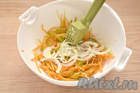 Очищаем половину луковицы, нарезаем на тонкие полукольца (или четверть кольца). Очищенные зубчики чеснока пропускаем через пресс. Лук с чесноком добавляем в салат из моркови и зелёной редьки.