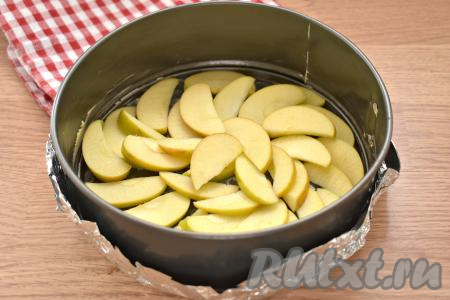 Яблоки тщательно промываем, удаляем семена, можно шкурку не очищать. Нарезаем яблоки на тонкие ломтики. Дно и бока формы для запекания (у меня круглая форма диаметром 20 сантиметров) смазываем кусочком сливочного масла. На дно равномерно выкладываем нарезанные яблоки.