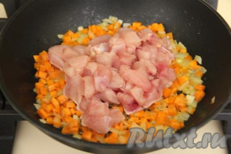 Обжаривать морковь с луком минут 5, иногда их перемешивая. Затем добавить куриное мясо, нарезанное на средние кубики, перемешать.