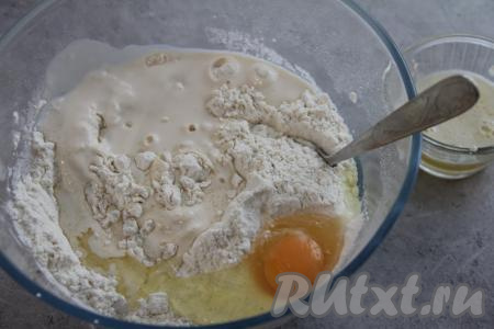 В получившуюся смесь муки, сахара и дрожжей добавить яйцо и тёплый кефир (или ряженку). Температура кефира (или ряженки) не должна быть выше 40 градусов. Перемешать получившееся тесто.