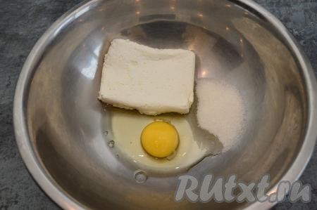 В глубокую миску вбить сырое яйцо, выложить творог и всыпать сахар.
