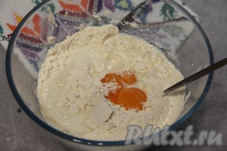 Добавить в миску яичные желтки и тёплое молоко (температура молока не должна быть выше 40 градусов), перемешать тесто.