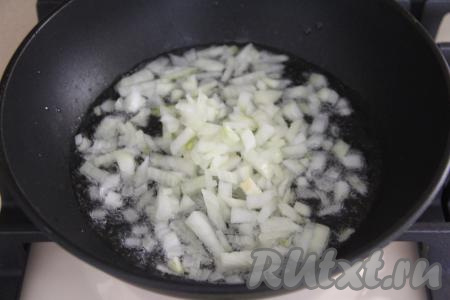 В сковороду влить растительное масло, затем добавить очищенный и мелко нарезанный лук. Обжарить лук в течение 5 минут на среднем огне, иногда перемешивая.