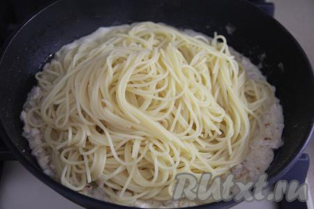 Готовые спагетти откинуть на дуршлаг и сразу же переложить в сковороду с фаршем в сливочном соусе, перемешать.