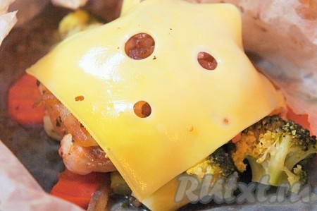 За 5-7 минут до готовности треску развернуть, добавить ломтики сыра и снова отправить в духовку, чтобы сыр расплавился.