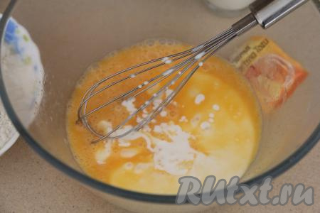 В смесь яиц и сахара влить кефир и снова хорошо перемешать венчиком.
