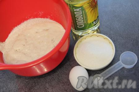 Влить опару в миску, в которой удобно будет замешивать тесто, добавить оставшийся сахар, сырое яйцо, влить растительное масло.