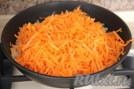 Затем добавить в сковороду морковку, натёртую на крупной тёрке, перемешать овощи и обжаривать их минут 7 (до мягкости моркови), иногда помешивая, затем убрать с огня, дать немного остыть.