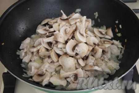 Обжарить куриное мясо с луком в течение 5 минут, периодически перемешивая. Затем добавить нарезанные шампиньоны, перемешать и жарить грибы до готовности (минут 15), не забывая иногда перемешивать.