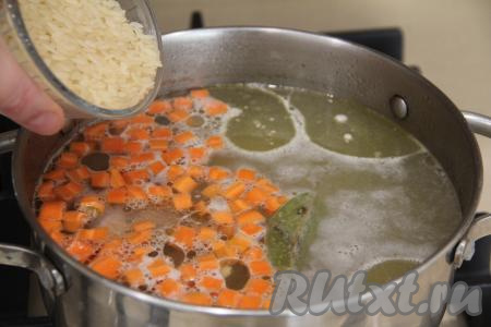 Всыпать рис (у меня пропаренный рис, я его не промывала), снова дать закипеть и уменьшить огонь, варить куриный суп 15 минут. 