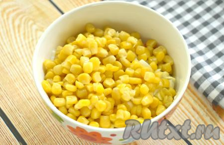 Откидываем консервированную кукурузу на сито, чтобы слить жидкость. Затем зёрна кукурузы добавляем в салат из копчёной курицы, яиц и крабовых палочек.