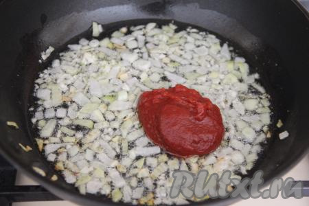 После того как лук обжарится, добавить к нему томатную пасту, перемешать.