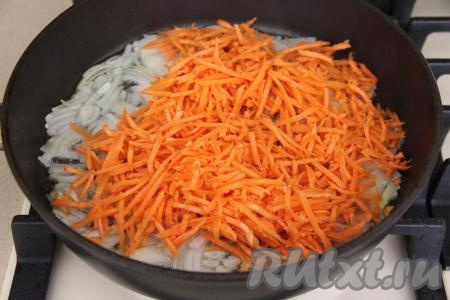 К луку, обжаренному до прозрачности, выложить натёртую на крупной тёрке морковку, перемешать и обжаривать овощи, периодически помешивая, минут 5-6 (до мягкости моркови).