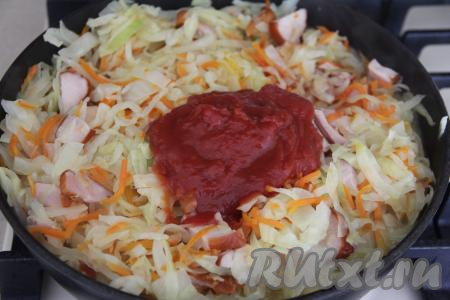 Затем добавить томатную пасту, перемешать, тушить капусту с копчёной курицей под крышкой ещё 10 минут.