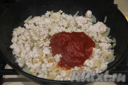 Обжарить фарш с луком, постоянно разбивая комочки мяса, в течение 10-15 минут. А затем добавить в сковороду томатную пасту, перемешать.
