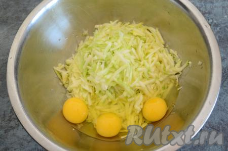В глубокую миску натереть очищенные кабачки на крупной тёрке. Всыпать соль по вкусу и вбить сырые яйца.