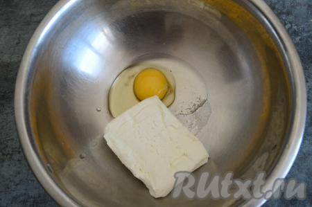 В миску вбить сырое яйцо, всыпать соль и выложить творог.
