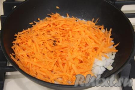 К обжаренному луку добавить морковку, натёртую на крупной тёрке, перемешать, обжаривать овощи, иногда помешивая, минут 5 (до мягкости моркови), затем убрать с огня.