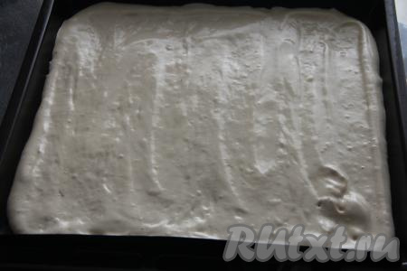 Застелить противень (у меня противень размером 50 на 40 сантиметров) ковриком (или пергаментом) для выпечки, выложить тесто, распределить его равномерно.