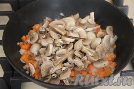 В сковороду с обжаренными овощами выложить шампиньоны (или подготовленные лесные грибы, или вешенки), перемешать.