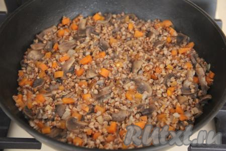 Накрыть сковороду крышкой и томить гречку с грибами, морковью и луком на медленном огне до полного испарения воды (минут 20-25), затем убрать с огня, перемешать.