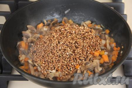 Обжарить грибы с овощами в течение 5 минут, не забывая время от времени помешивать, затем добавить гречку. 