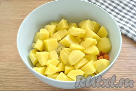 Очищенные картошины нарезаем на небольшие кубики, добавляем в миску с мясом и овощами.