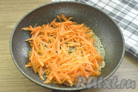 К луку, обжаренному с чесноком, добавляем натёртую на крупной тёрке морковку, перемешиваем, обжариваем овощи, иногда помешивая, минуты 3-4.