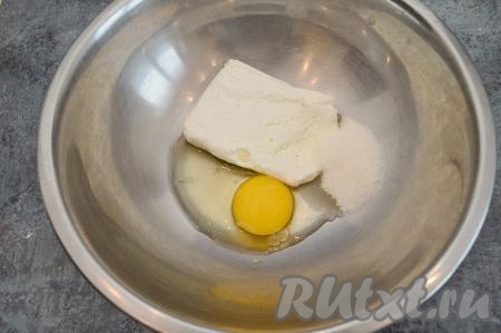 В глубокую миску выложить творог, сахар и сырое яйцо.