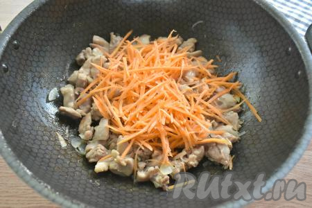 Морковку нарезаем тонкой соломкой (или натираем на крупной тёрке), выкладываем к кусочкам мяса, обжаренным с луком, перемешиваем, обжариваем, периодически помешивая, 5 минут.