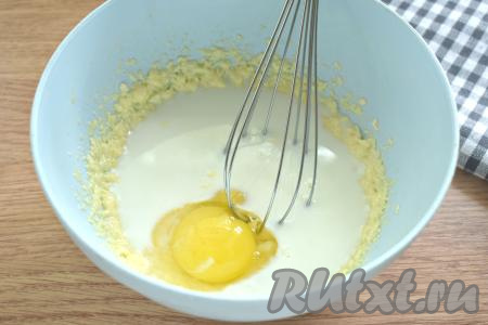 В получившуюся смесь разбиваем яйцо, вливаем тёплое молоко, снова перемешиваем (лучше перемешивать ручным венчиком, чтобы молоко не разбрызгалось).