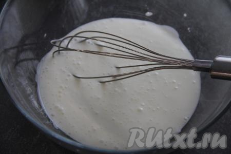Влить в объёмную миску кефир, всыпать соду, перемешать венчиком и оставить на 4-5 минут. Сода вступит в реакцию с кефиром и масса увеличится в объёме.