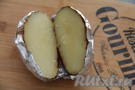 Готовый запечённый картофель достать из духовки, дать немного остыть. Затем каждую картошину разрезать прямо с фольгой на две части и размять сердцевину вилкой.