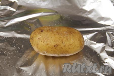 Картофель нужно выбирать крупный, желательно примерно одного размера. Можно готовить картошку в кожуре или без неё. Я запекала в кожуре, предварительно вымыв каждую картошину и поскоблив её железной щёткой. Каждую картошину выложить на отрезанный кусок фольги. Обмазать каждую картофелину растительным маслом со всех сторон и слегка посолить.
