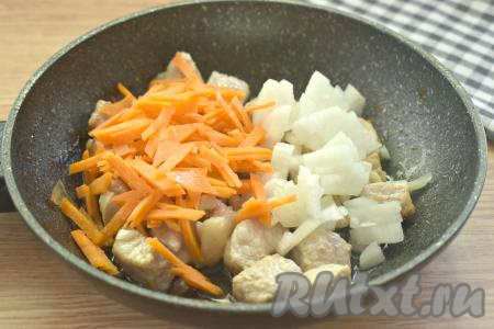 Очищаем морковку и лук. Морковь нарезаем на достаточно тонкие брусочки, лук - на небольшие кусочки, затем выкладываем нарезанные овощи к обжаренным кусочкам мяса. Перемешиваем, обжариваем овощи со свининой 5 минут, иногда перемешивая.