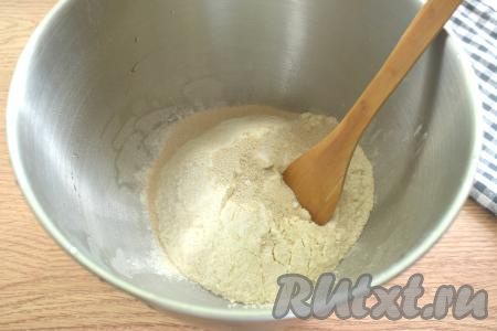 В объёмную миску просеиваем муку, сразу добавляем сахар, соль и дрожжи, хорошо перемешиваем, образуя в центре углубление.