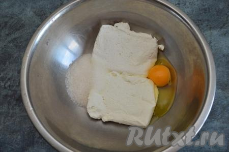 В глубокую миску выложить творог, всыпать сахар и вбить сырое яйцо.