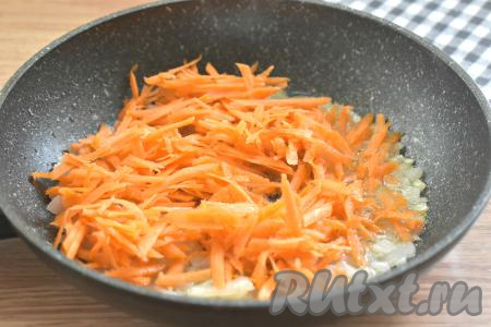 К обжаренному луку выкладываем морковку, натёртую на крупной тёрке, перемешиваем, обжариваем 3-4 минуты, иногда помешиваем, чтобы овощи не пригорели.