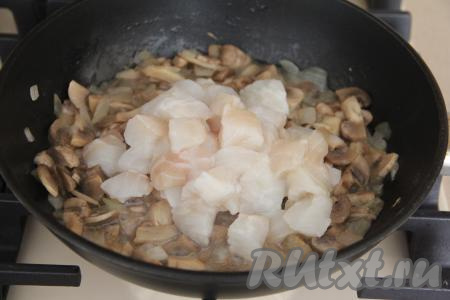 Филе рыбы нарезать на кусочки размером 2 сантиметра на 2 сантиметра, добавить к шампиньонам, обжаренным с овощами, перемешать и готовить 5 минут, иногда перемешивая.