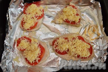 По прошествии 10 минут вынуть противень. Посыпать помидоры сверху натёртым сыром и отправить куриное филе в духовку ещё на 10 минут, чтобы сыр как следует расплавился.