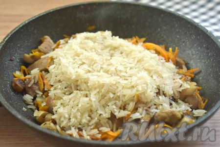 К свинине, обжаренной с овощами и шампиньонами, всыпаем подготовленный рис.