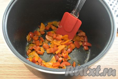 Вливаем в чашу мультиварки растительное масло и включаем режим "Жарка" на 10 минут. В разогревшееся масло выкладываем нарезанные лук, морковку и болгарский перец. Обжариваем овощи до окончания режима "Жарка", периодически перемешивая.