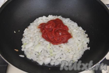 К обжаренному луку выложить томатную пасту, перемешать и готовить, периодически помешивая, 2-3 минуты.