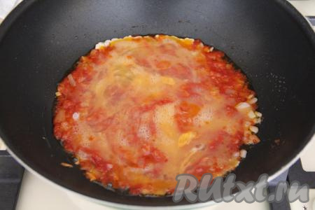В небольшой ёмкости яйца слегка взбить вилкой, затем влить их в сковороду с луком, обжаренным с томатной пастой.