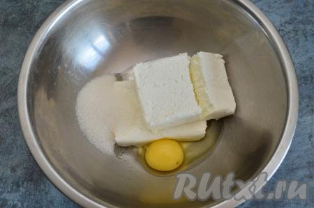 В глубокую посуду выложить творог, сырое яйцо, всыпать сахар.