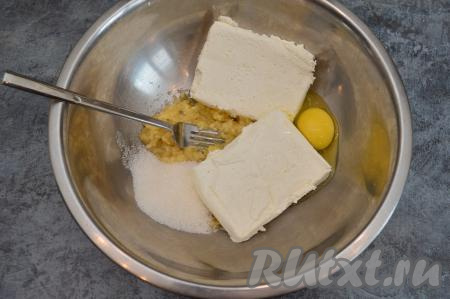 В миску с банановым пюре выложить творог, сахар и сырое яйцо.