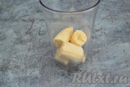 В чашу погружного блендера выложить банан, разломанный на крупные кусочки.