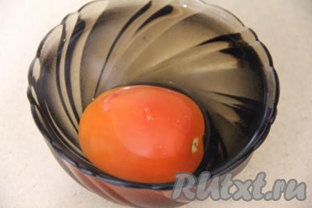 Залить помидор крутым кипятком и оставить на несколько минут, затем достать его, обдать холодной водой и снять с него шкурку. 