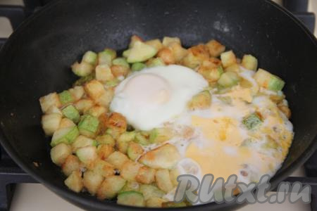 Накрыть сковороду крышкой и готовить яичницу с кабачками 5 минут на медленном огне.